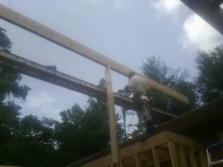 Carpenter setting a ridge beam over a new addition frame — Ice Dam Removal by Roofing Brothers in Perryville